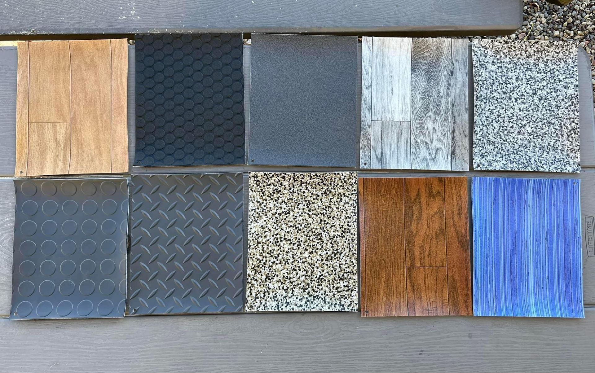 A variety of different types of tiles are lined up on a table.