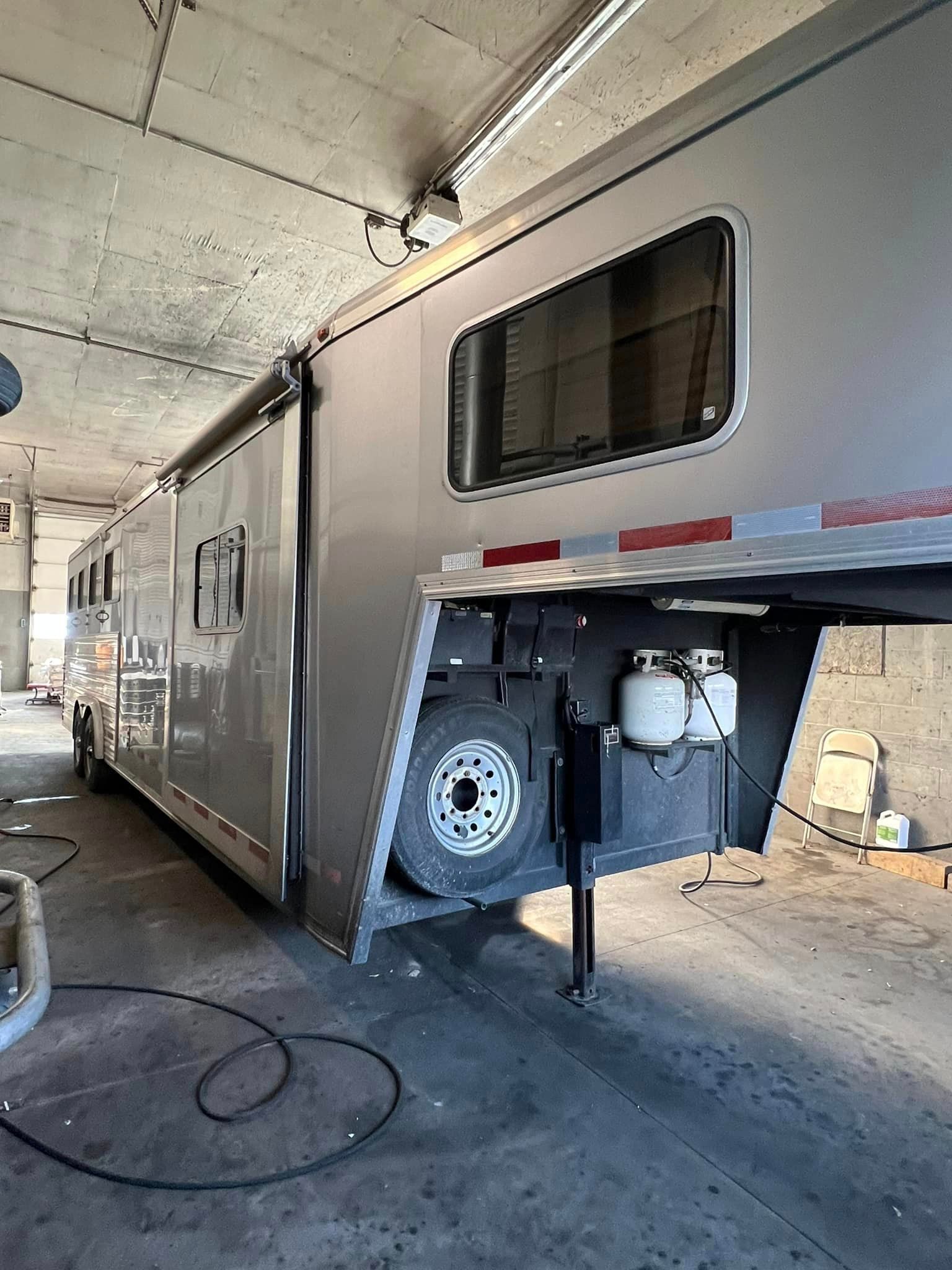 A horse trailer is parked in a garage.