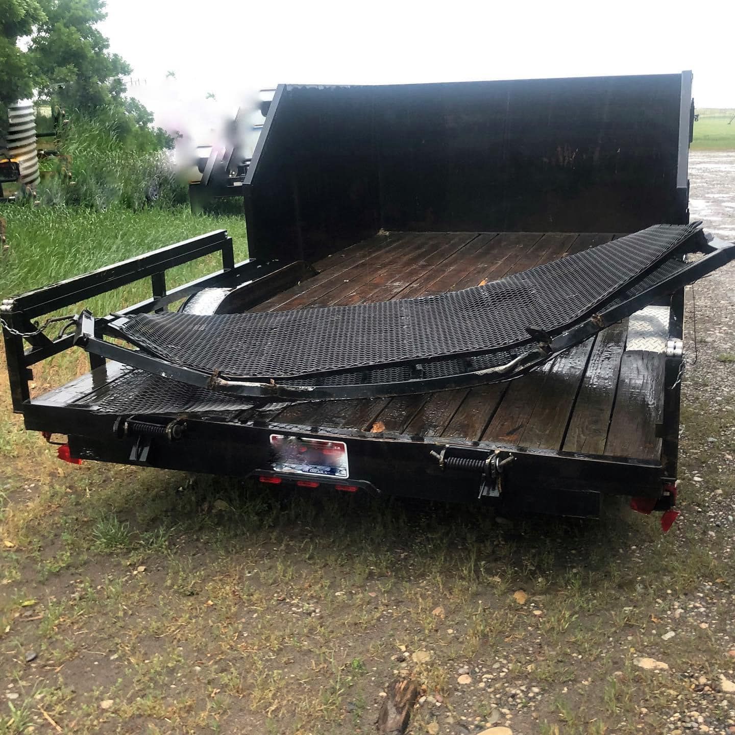A black trailer with a hammock on the back of it.