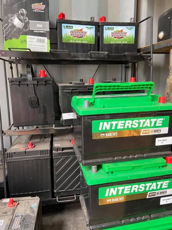 A bunch of interstate batteries are stacked on top of each other on a shelf.