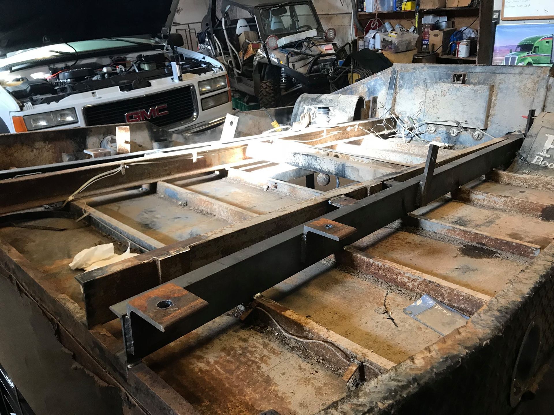 A large piece of metal is sitting on top of a wooden table in a garage.