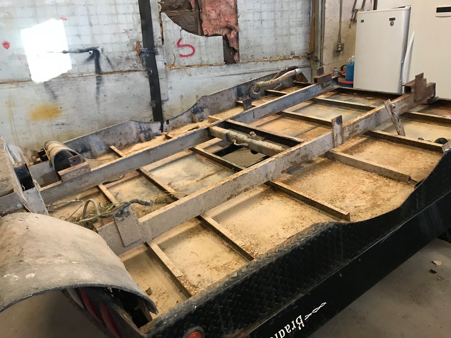 A wooden trailer is being built in a garage.