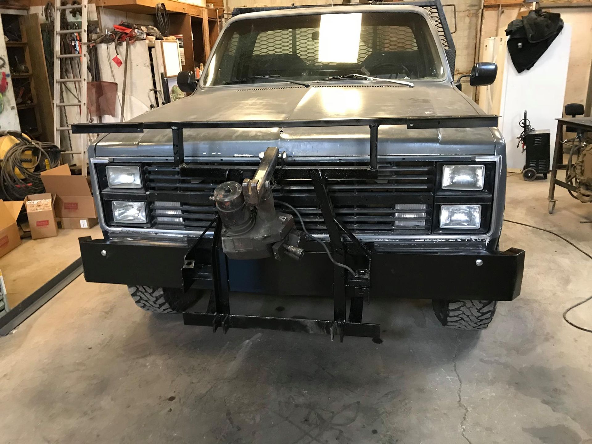 A truck with a trailer attached to it is parked in a garage.