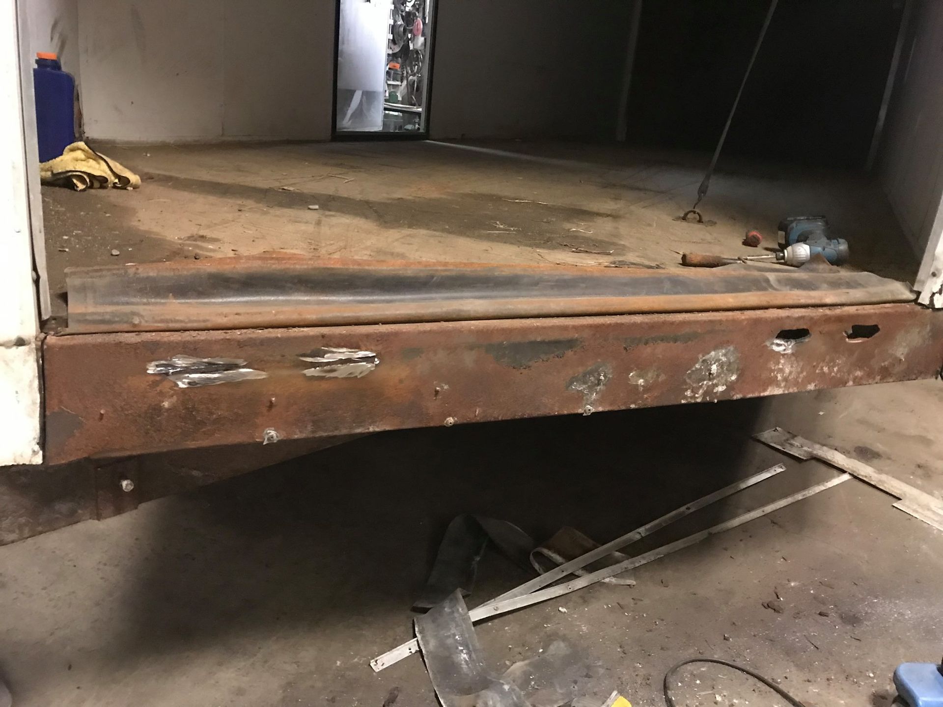 A rusty piece of metal is sitting on the ground in a garage.