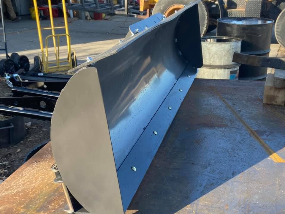 A large black bucket is sitting on a metal surface.