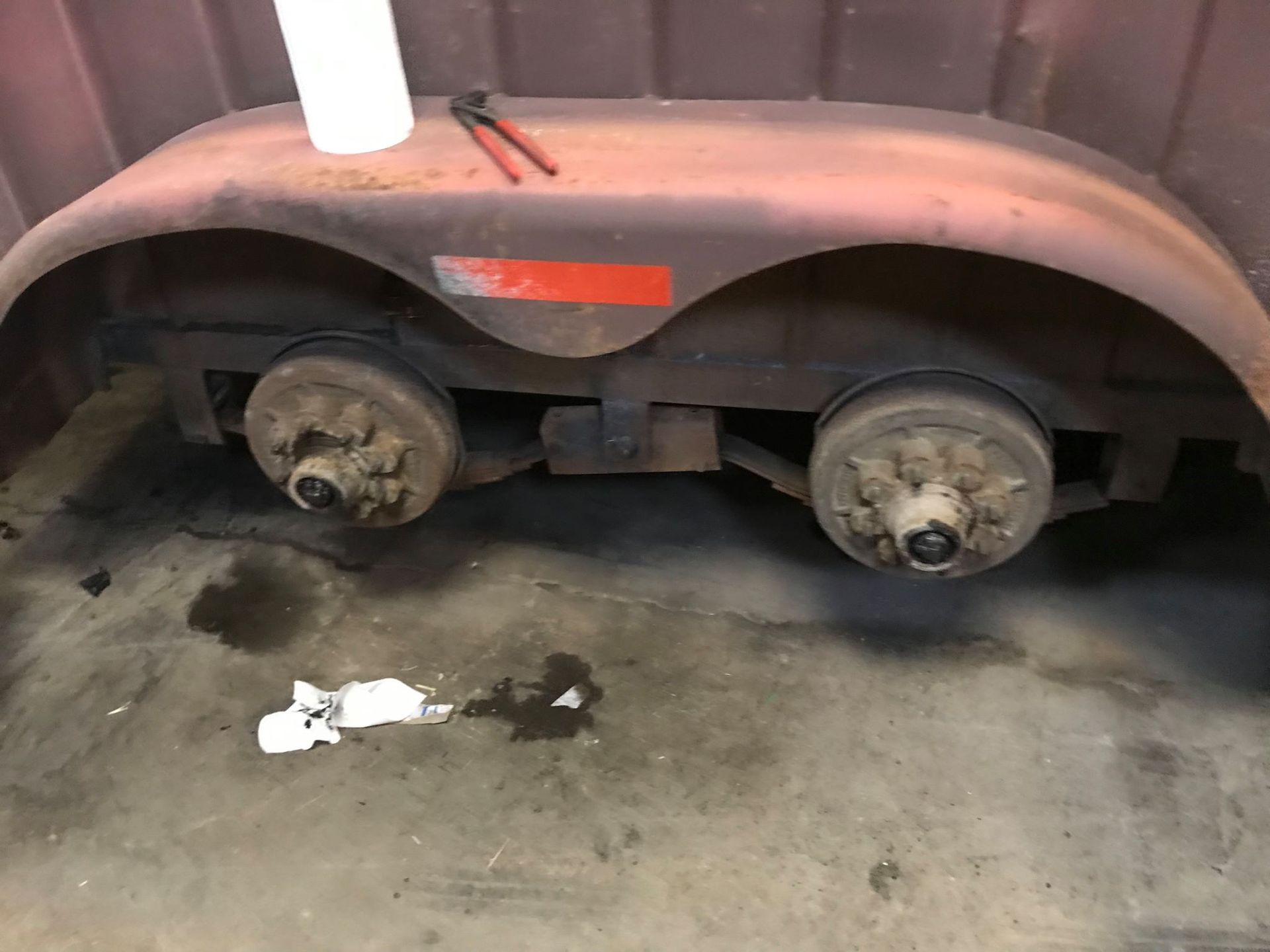 A trailer is sitting on the ground in a garage.