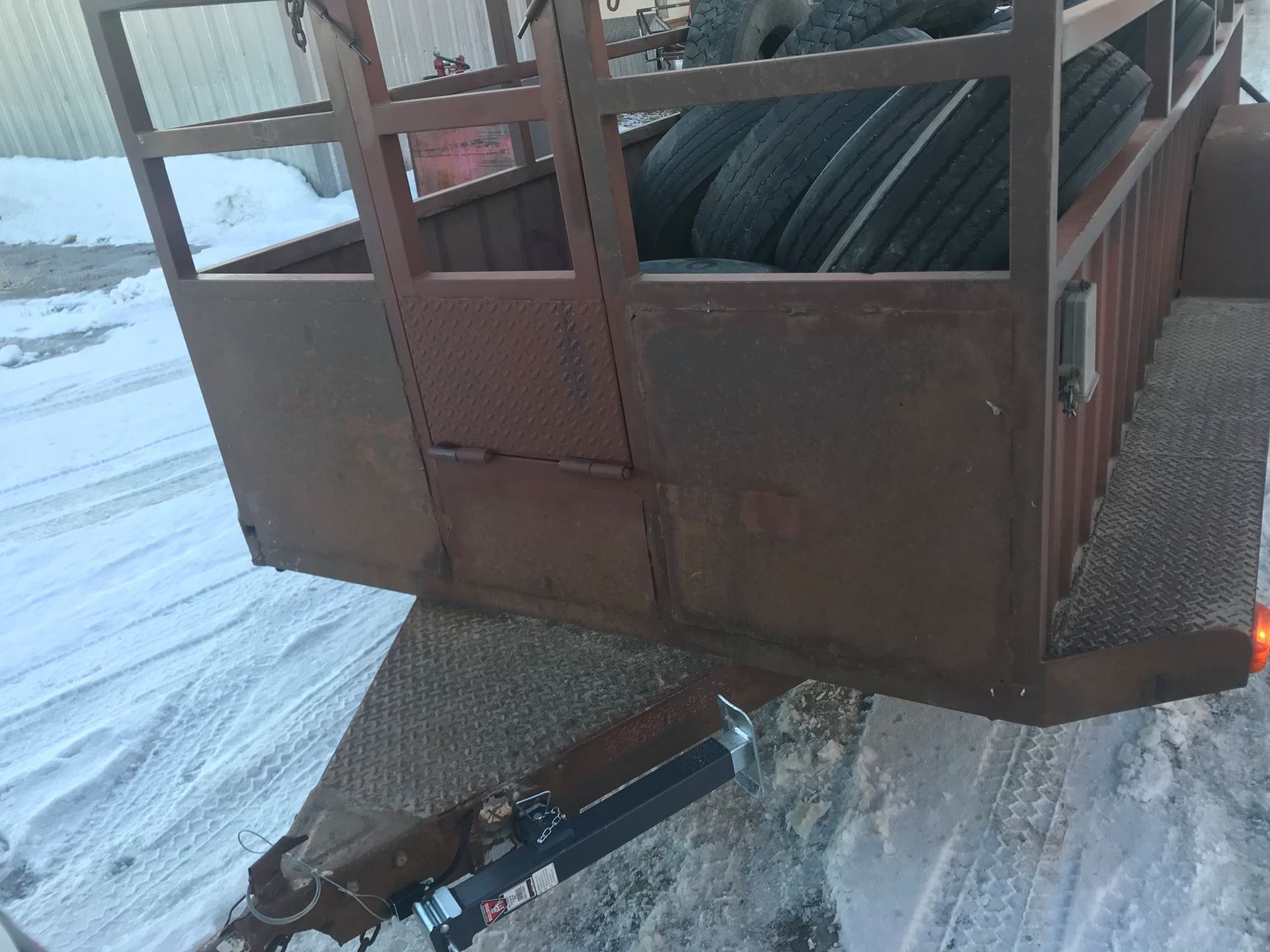 A trailer filled with tires is parked in the snow