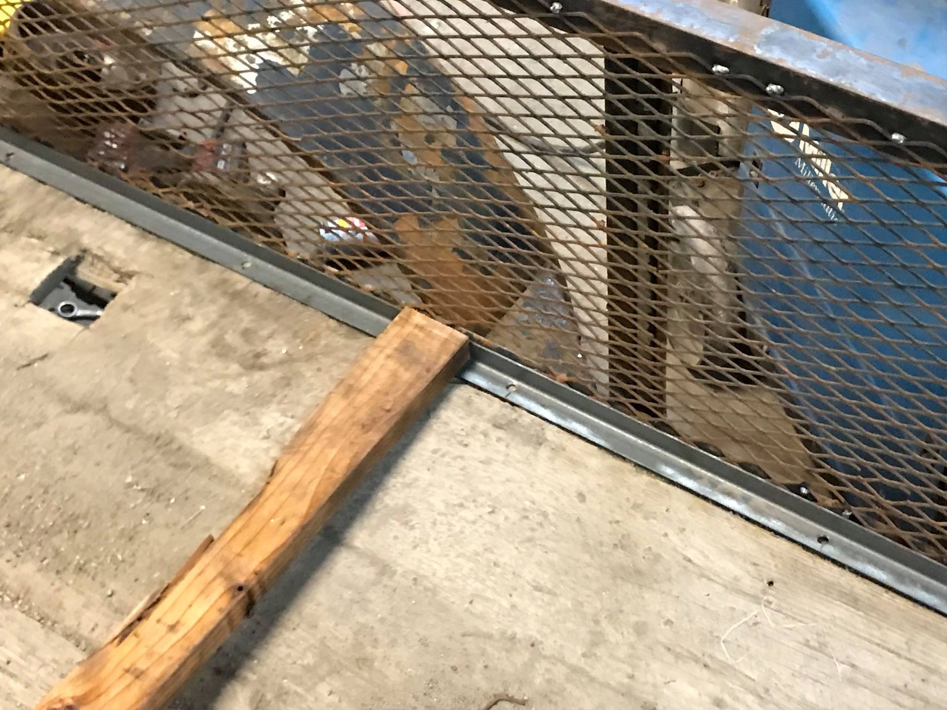 A wooden pole is sitting next to a metal fence.