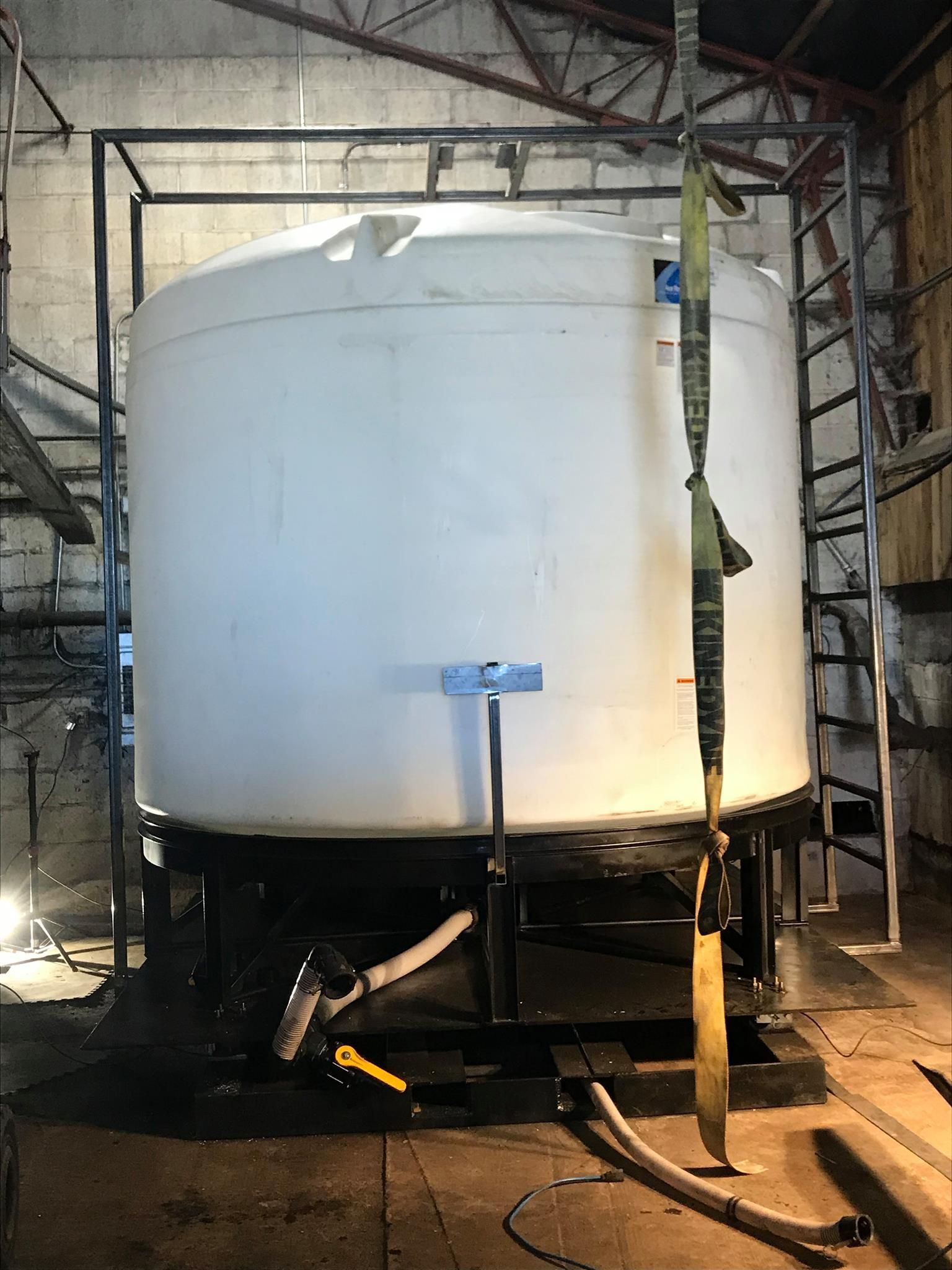 A large white tank is sitting in a warehouse.