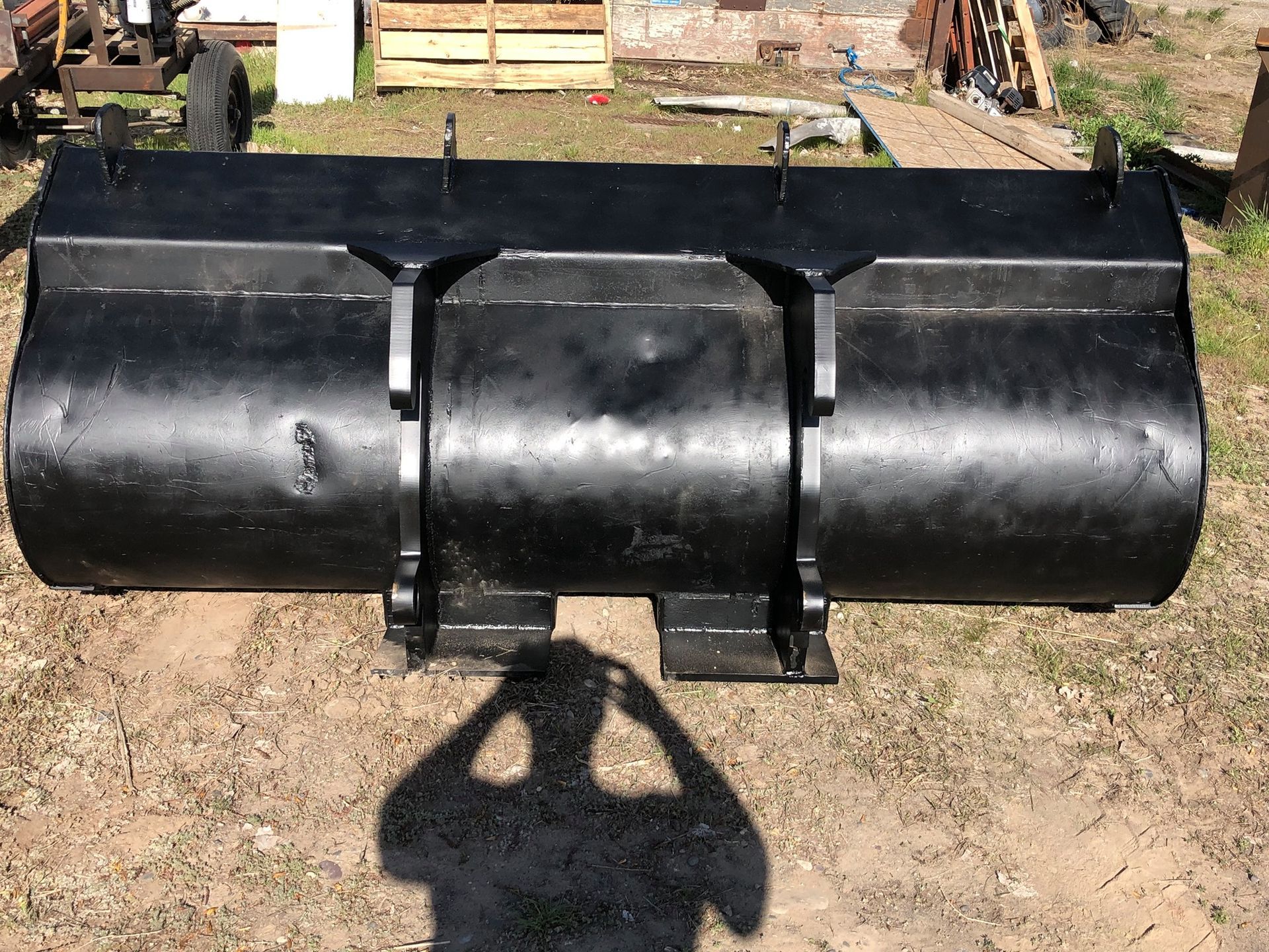 A shadow of a person is cast on a large black object