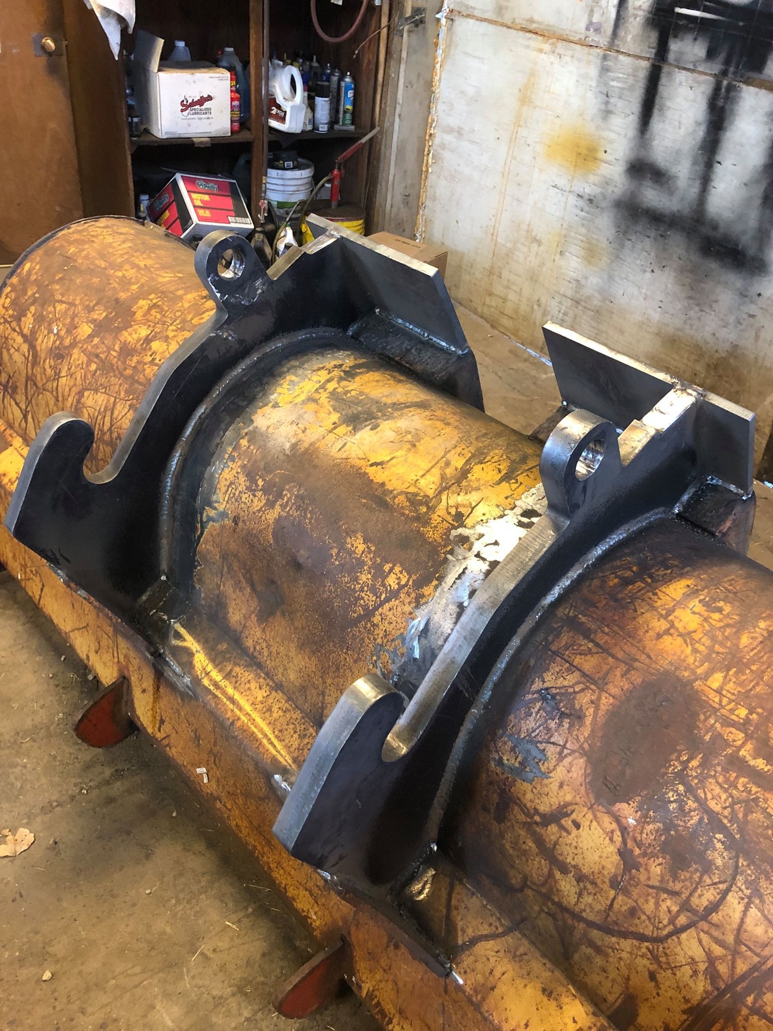 A large piece of rusty metal is sitting in a garage.