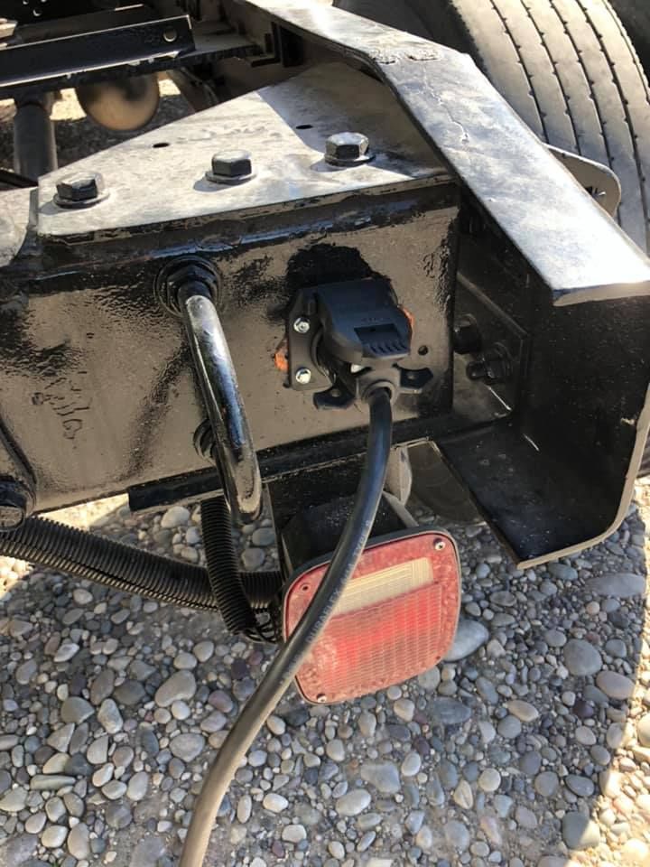 A close up of a truck with a hose attached to it.