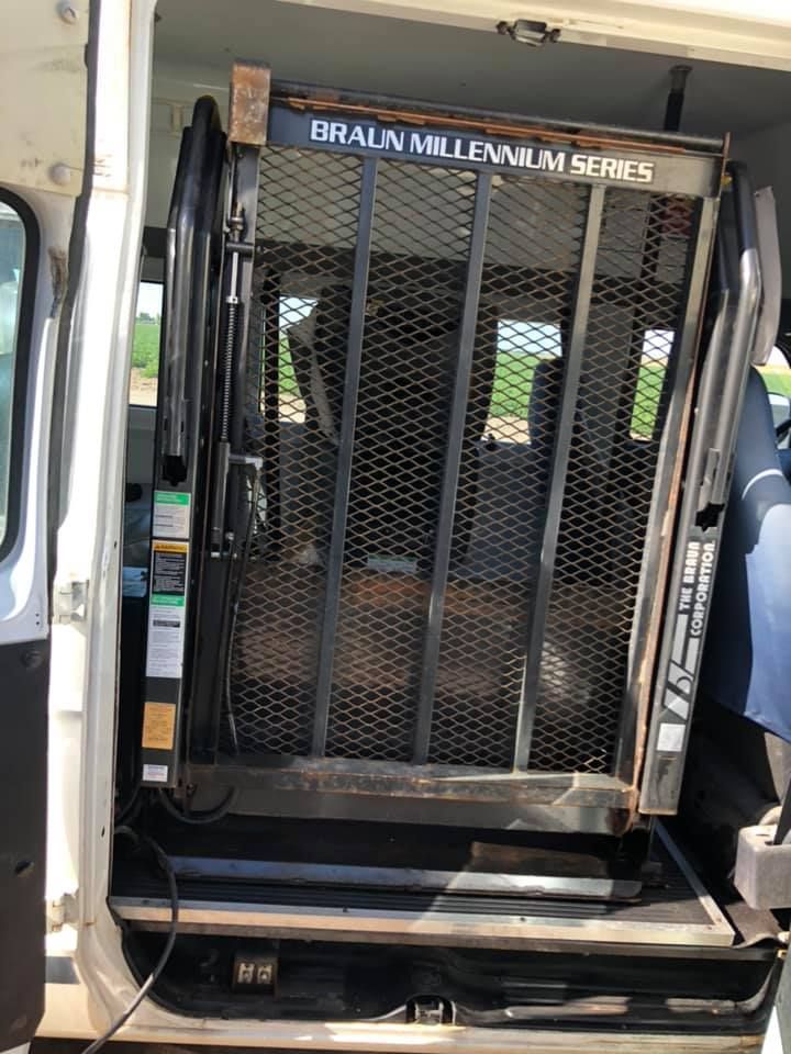 A wheelchair lift is sitting in the back of a van.