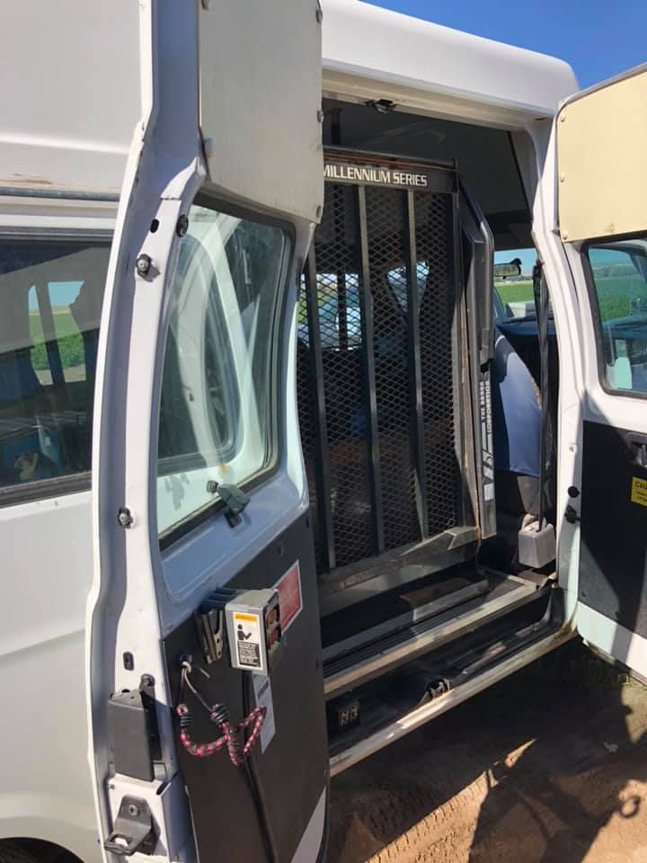 A white van with the door open is parked on the side of the road.