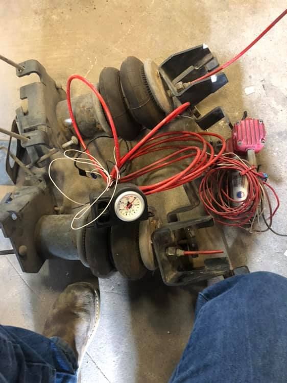 A bunch of wires are connected to a machine on the floor.