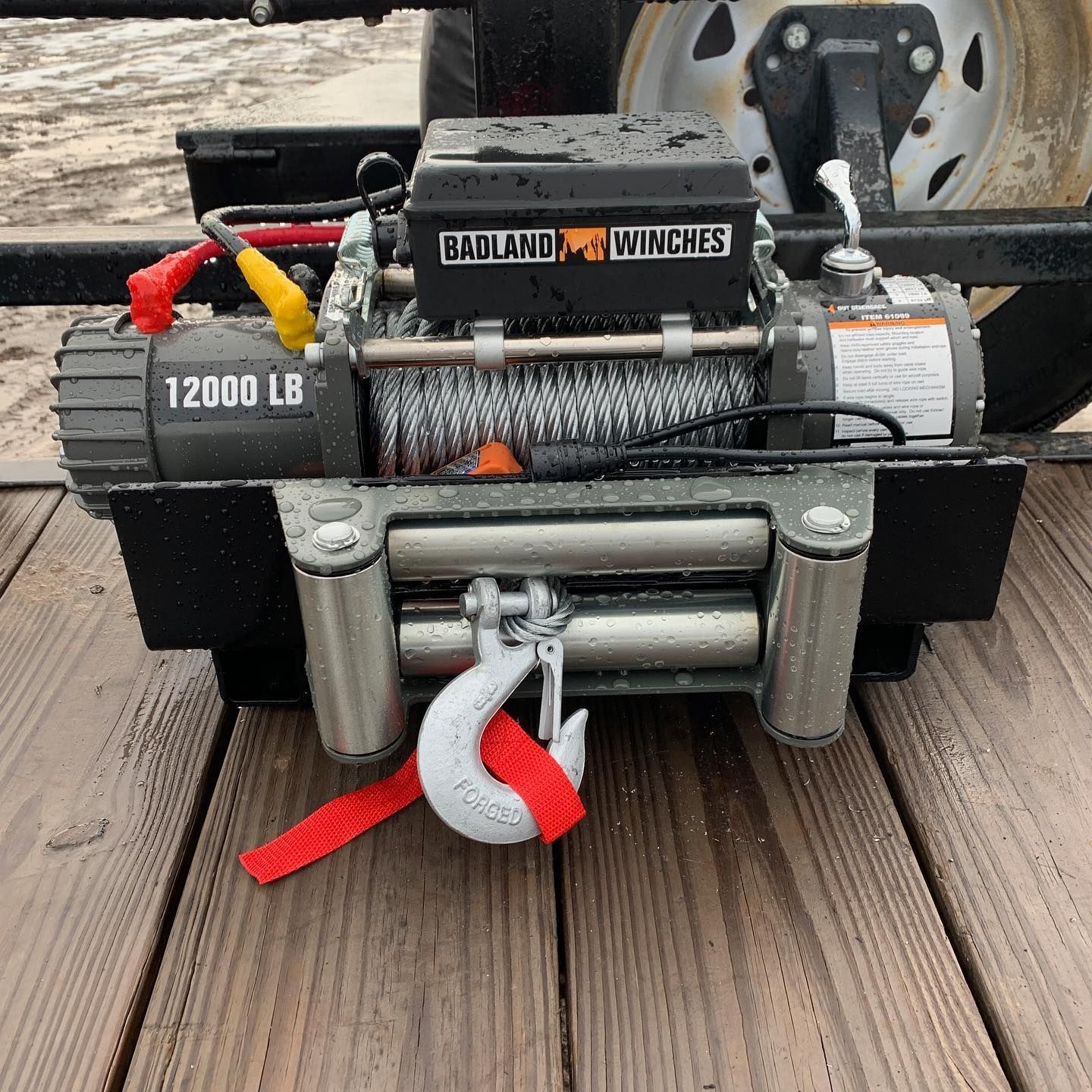A 12000 lb winch is sitting on a wooden deck