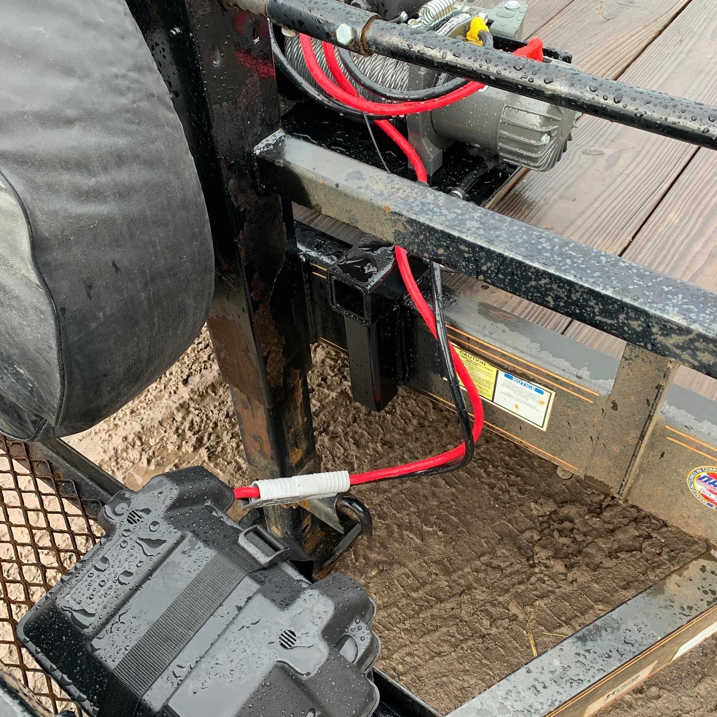 A close up of a trailer with a battery and wires attached to it.
