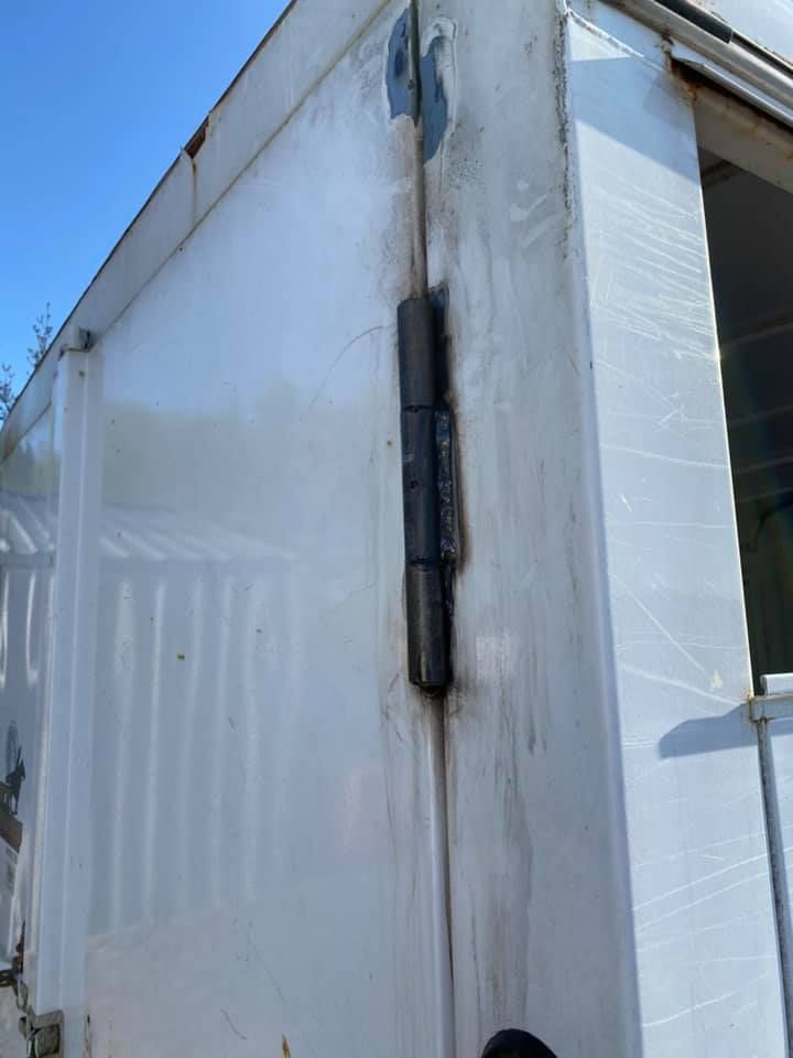 A white truck with a black hinge on the side of it.