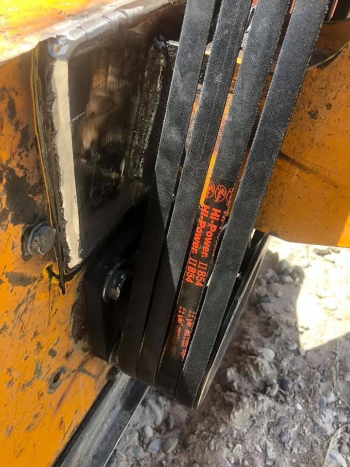 A close up of a belt on a yellow vehicle.