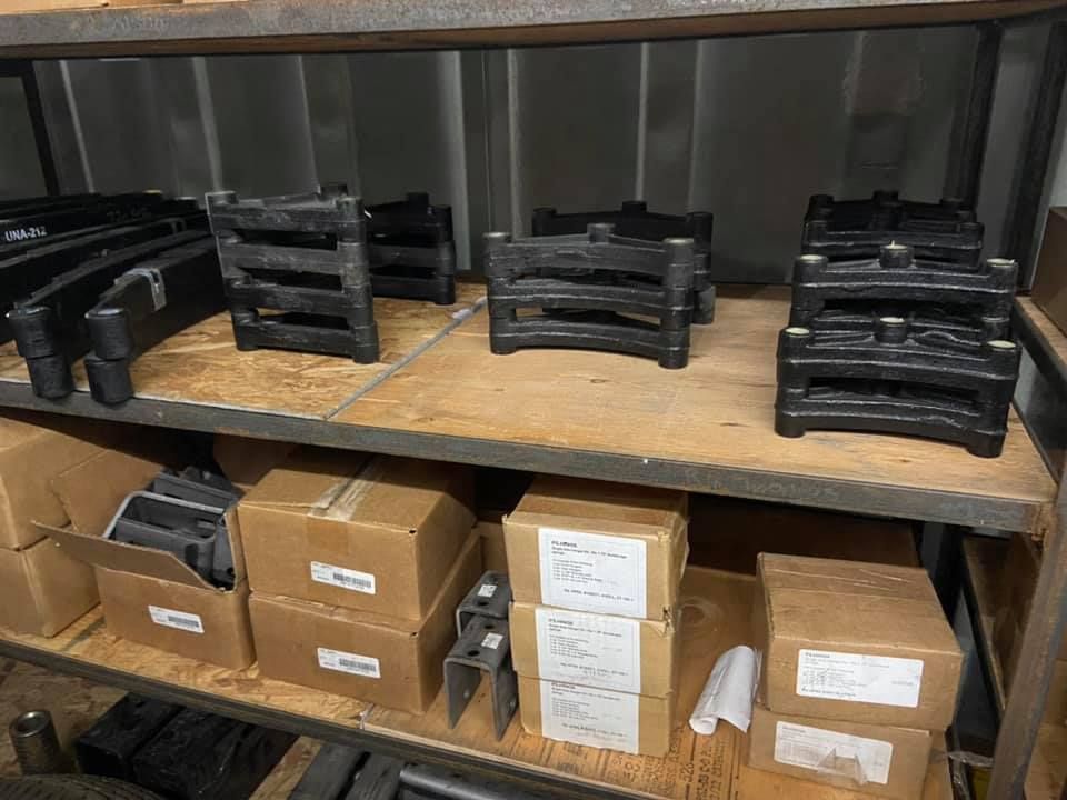 A shelf filled with boxes and pieces of metal.