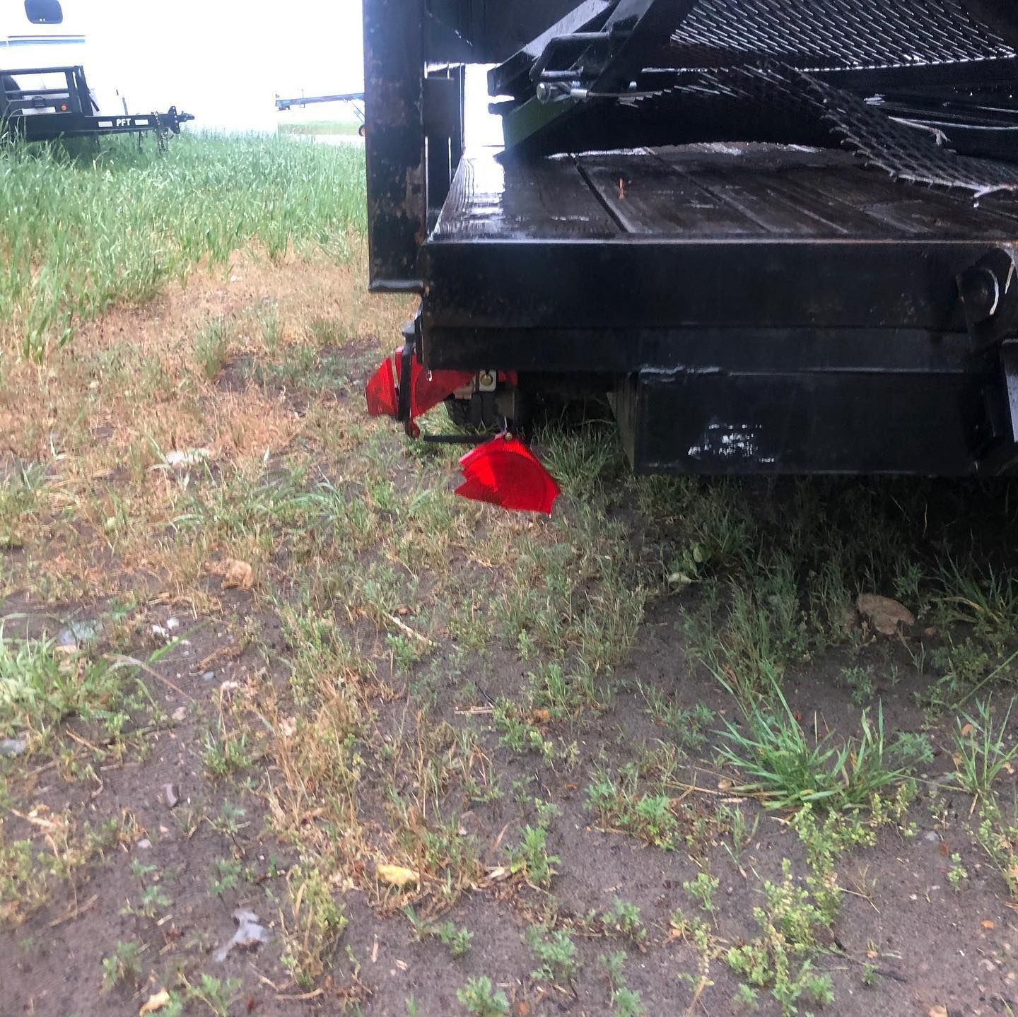 A black truck with red wheels is parked in the grass
