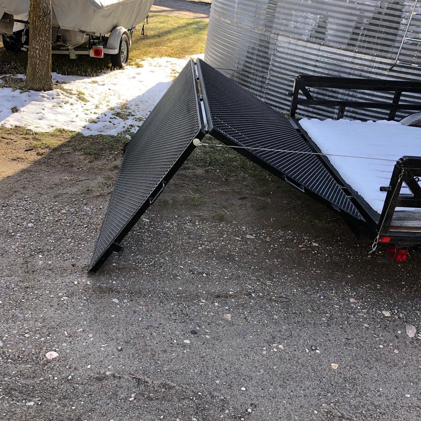A trailer is sitting on the ground next to a boat.