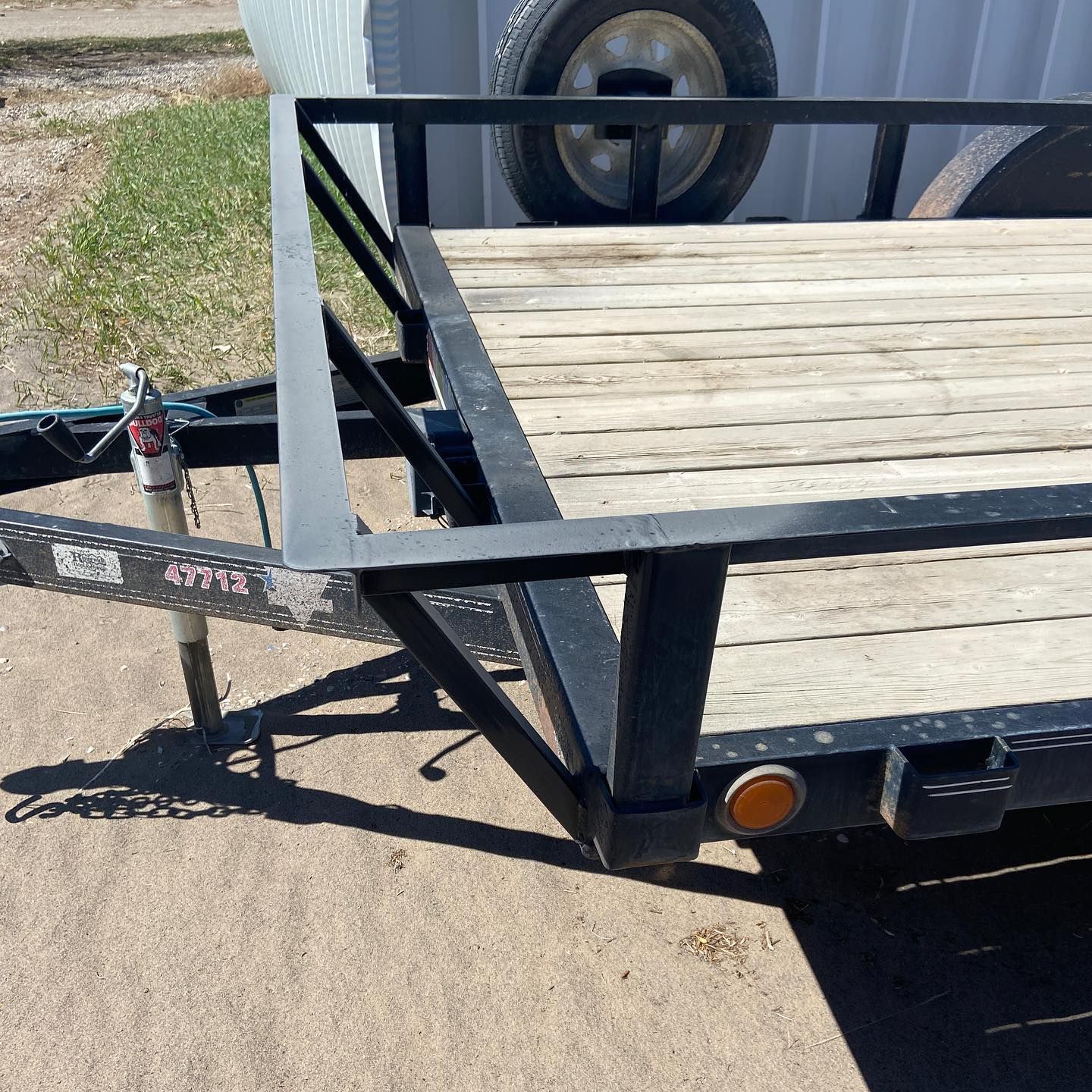 A trailer with a wooden deck and a black frame