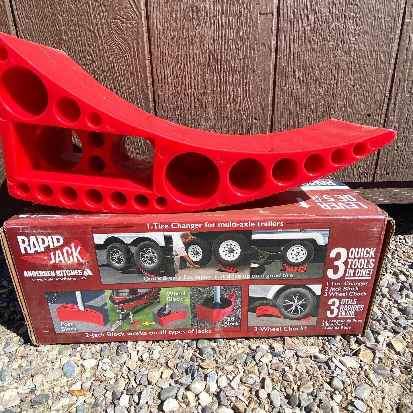 A red rapid jack is sitting on top of a box.