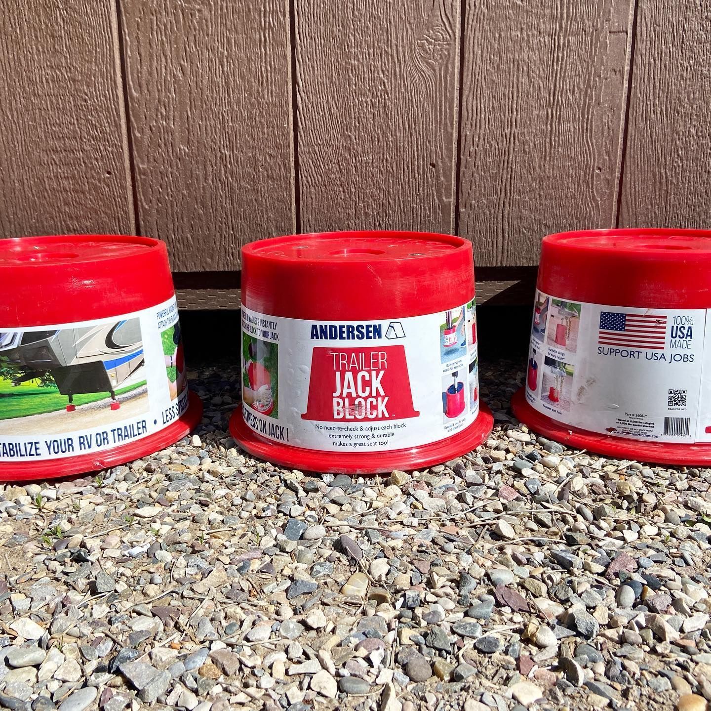 Three containers of tiny jack block are sitting on a pile of gravel.