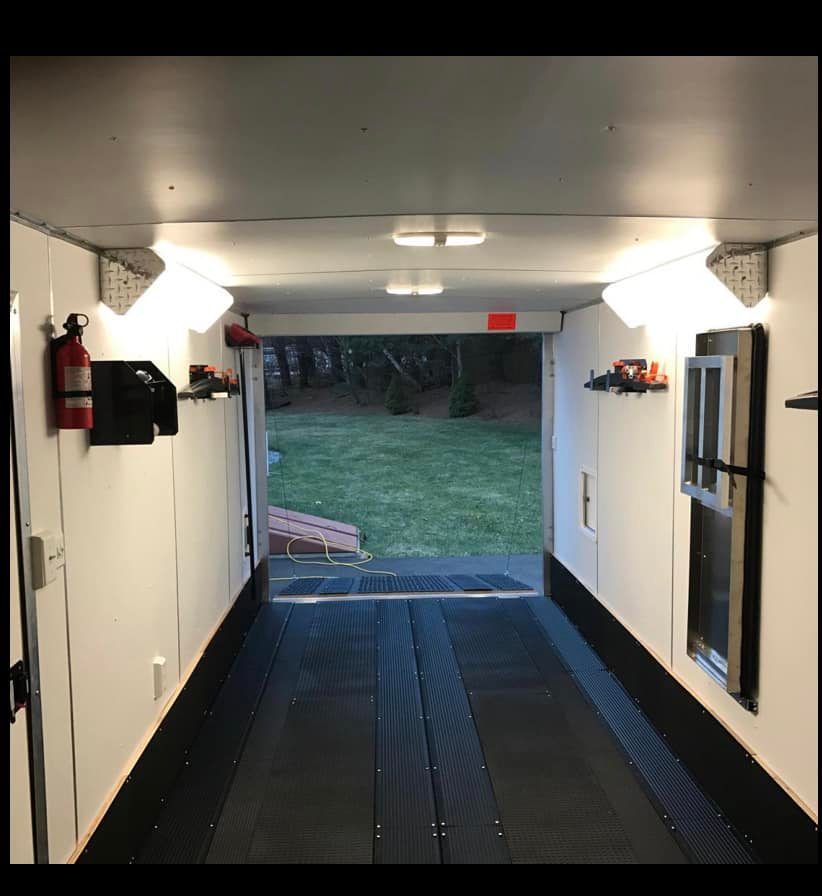 The inside of a trailer with a fire extinguisher on the wall.
