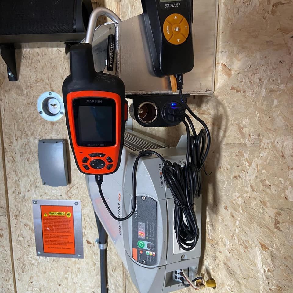 A gps device is hanging from a hook on a wall