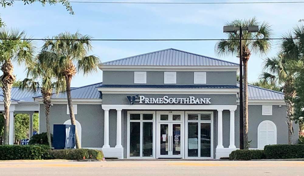 Prime South Bank building with gray exterior and palm trees.