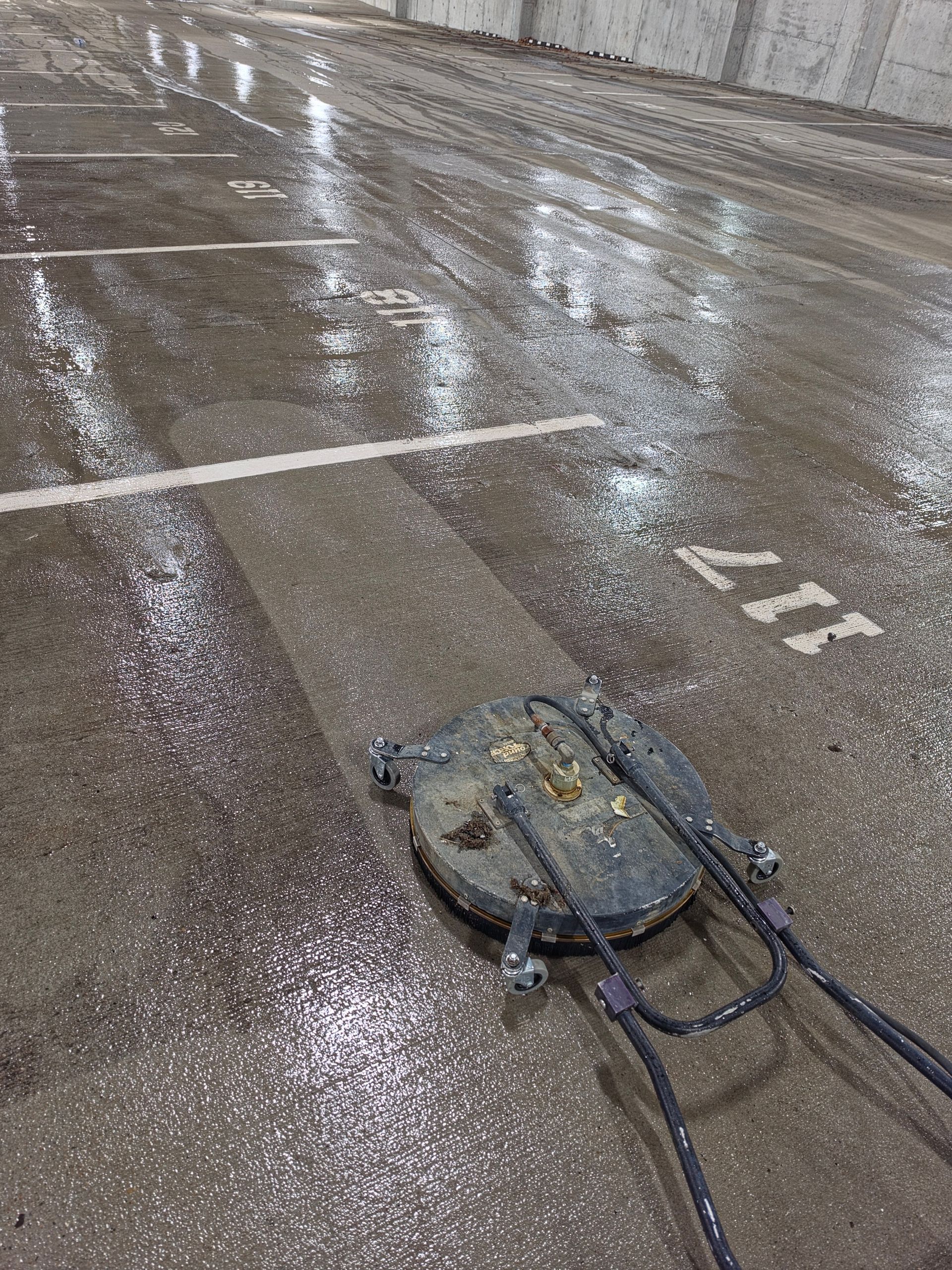Wet parking lot with a snowy patch and a blue backpack on the ground, with car tire tracks nearby