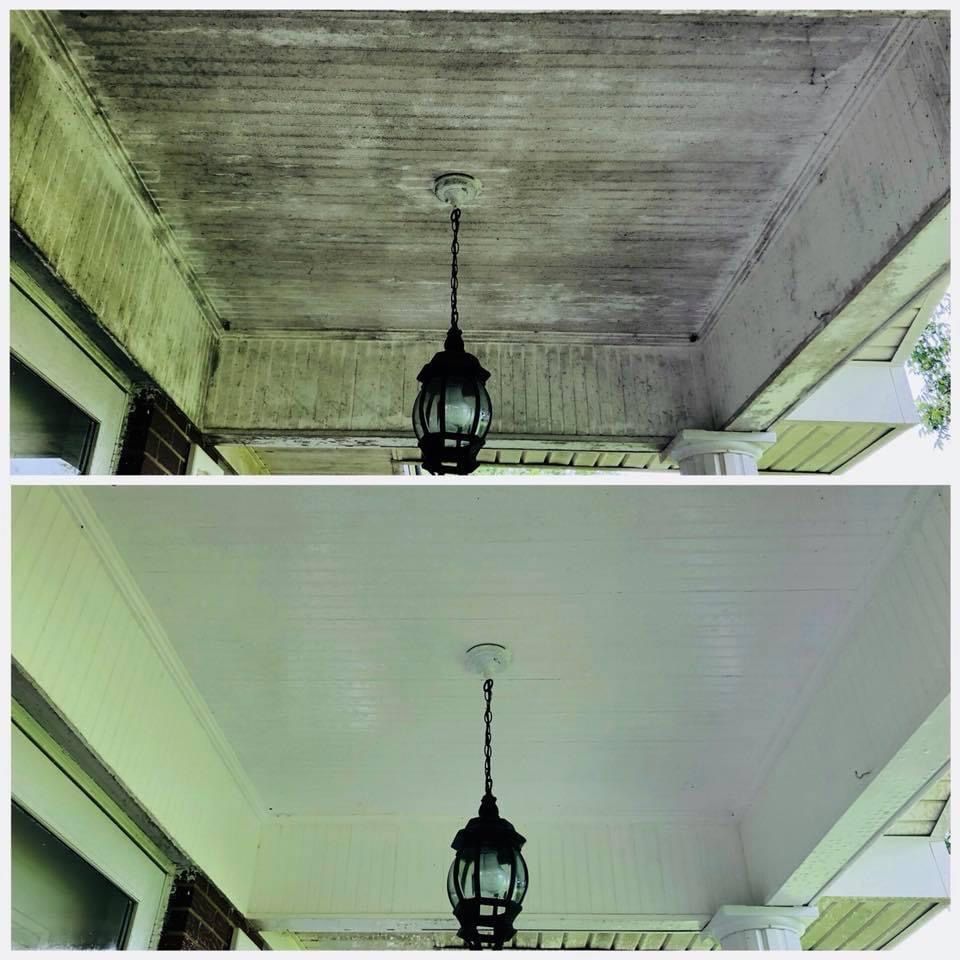 Split view of a porch ceiling and hanging lantern, showing darker textured wood above and lighter painted wood below