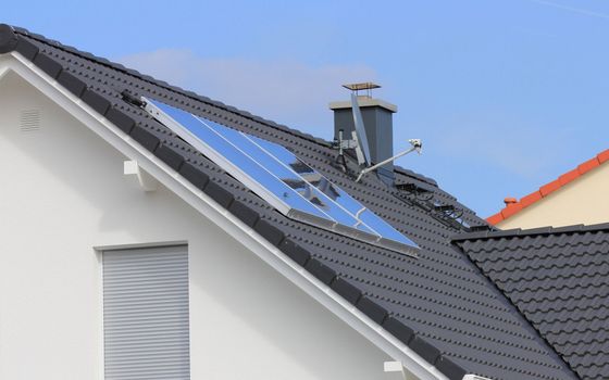 A roof with a window and solar panels on it