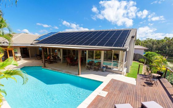 A house with a swimming pool and solar panels on the roof.