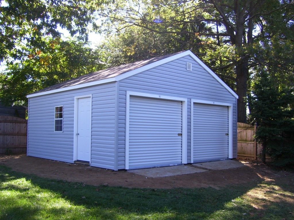 A white garage with two garage doors and a window