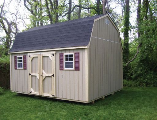 A barn shed with a black roof and red shutters