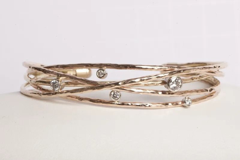 Gold-toned bracelet with interwoven bands and scattered clear crystals.