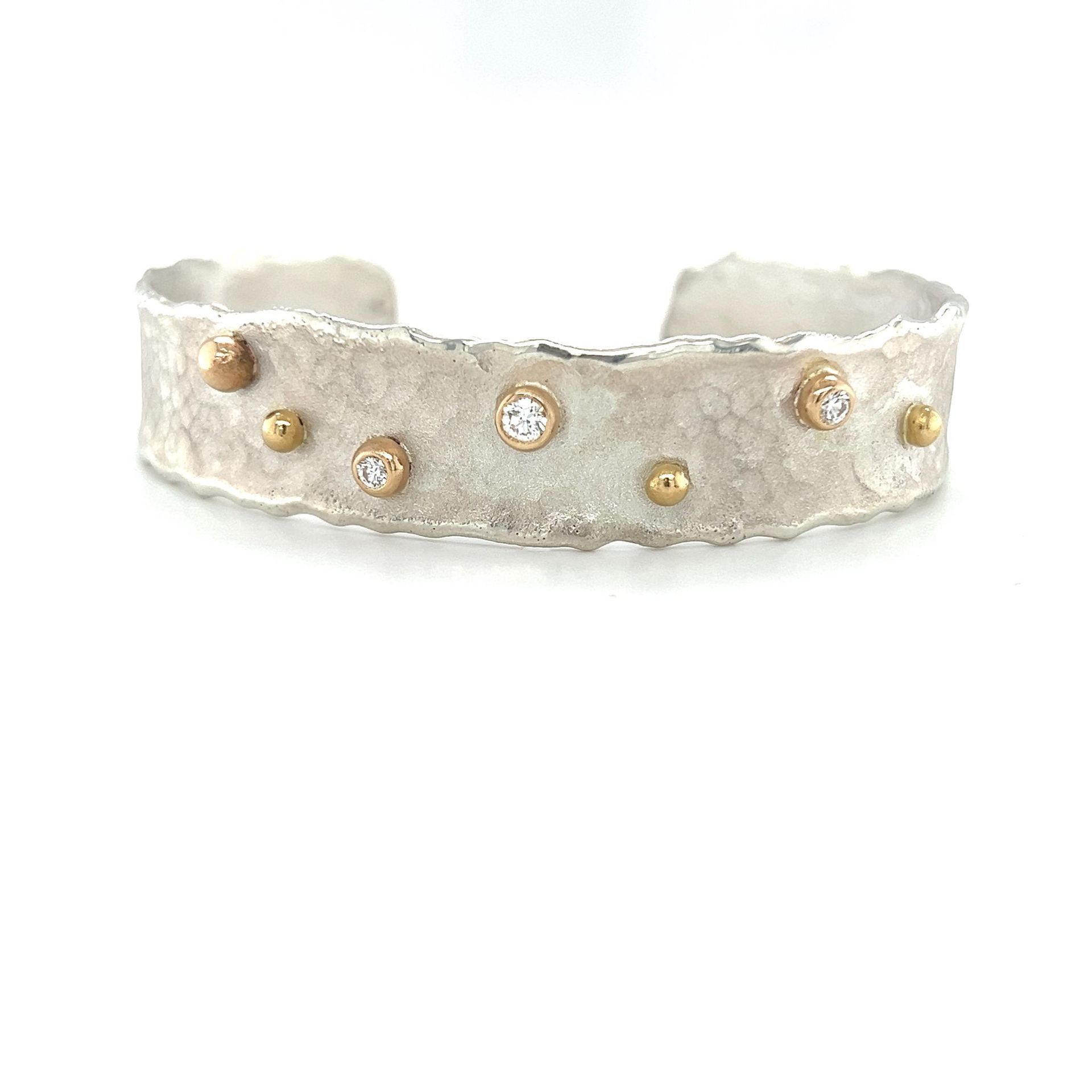 Silver cuff bracelet with gold and diamond embellishments.