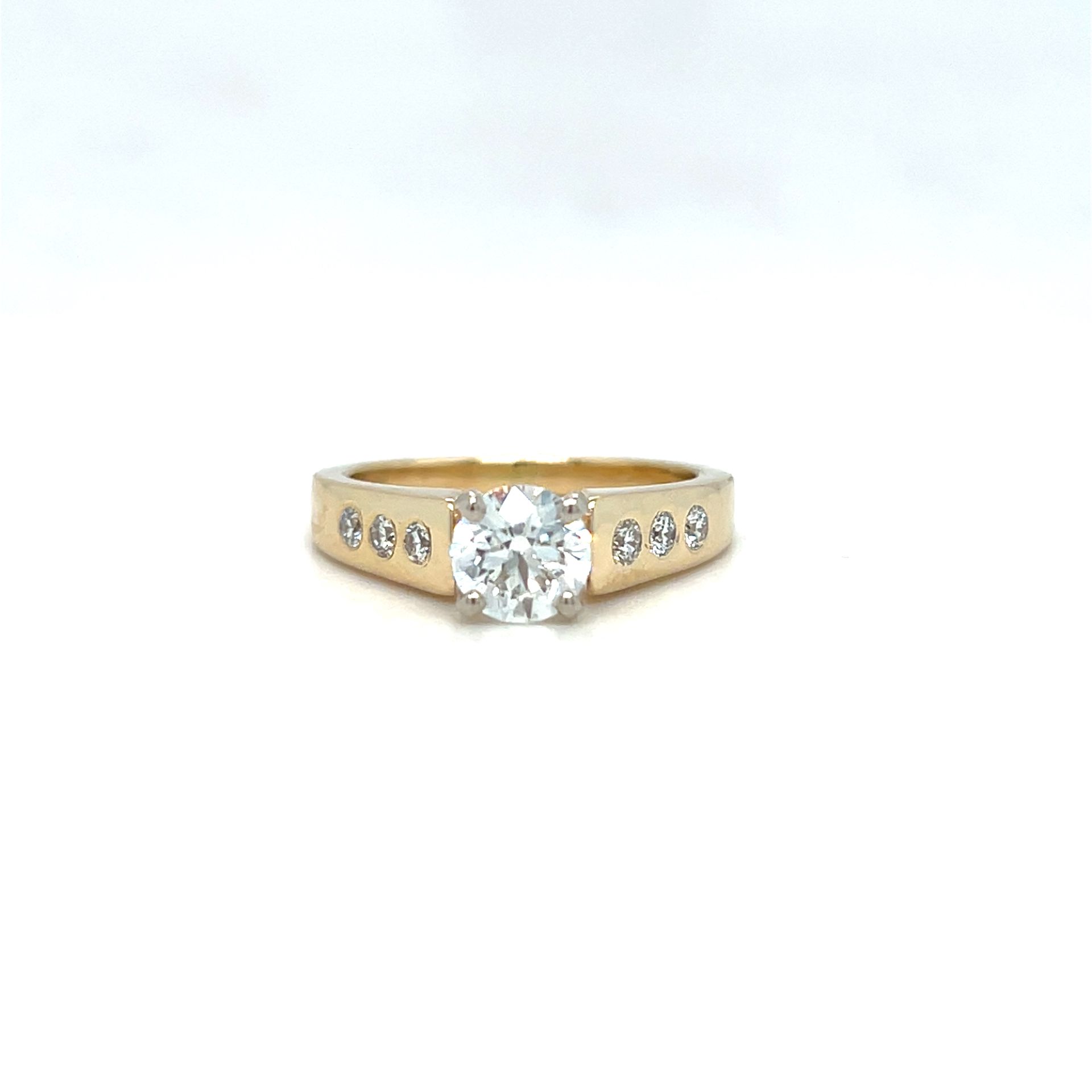 Gold ring with a large central clear stone and smaller side stones.