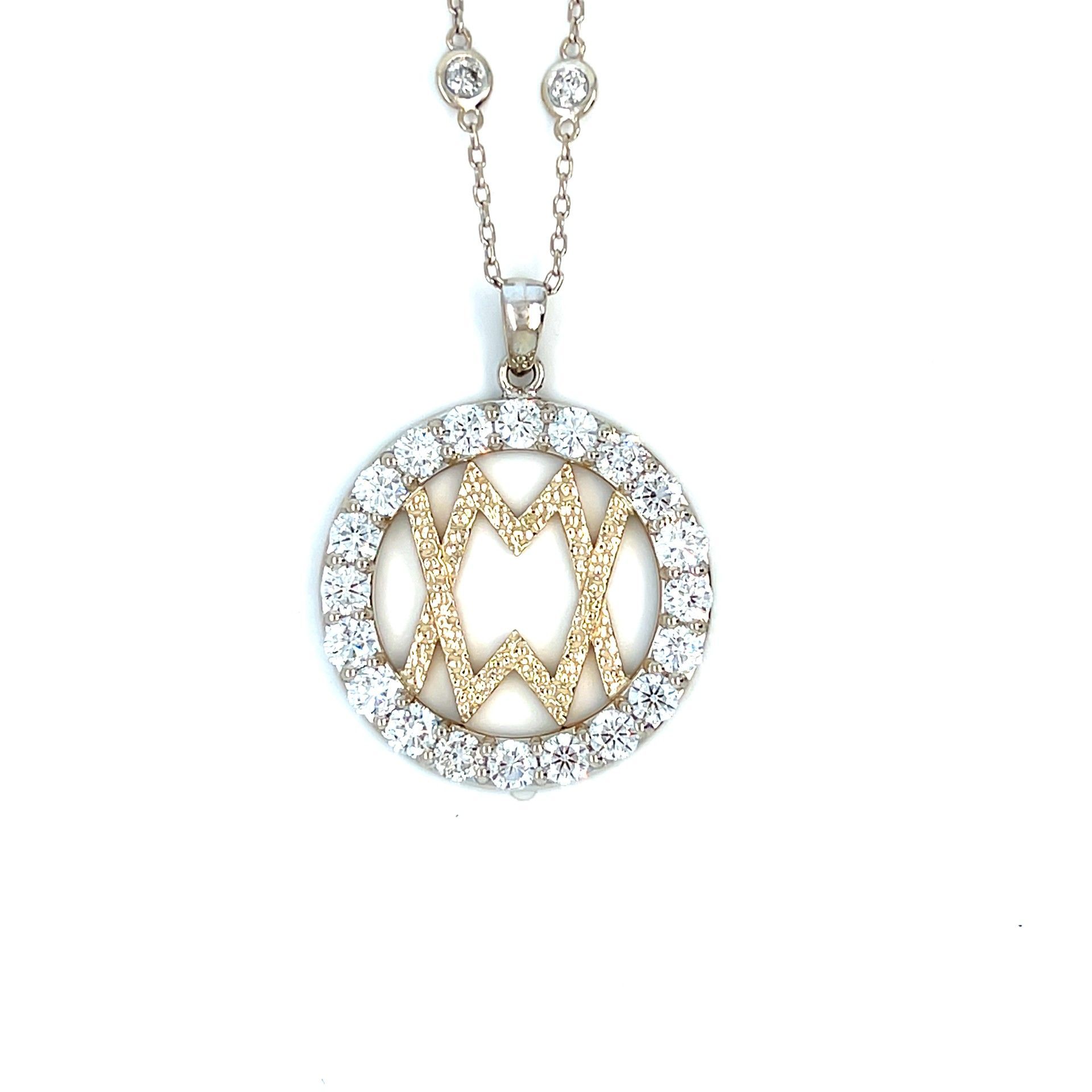 Silver necklace with a round pendant featuring a gold design within a circle of clear stones.