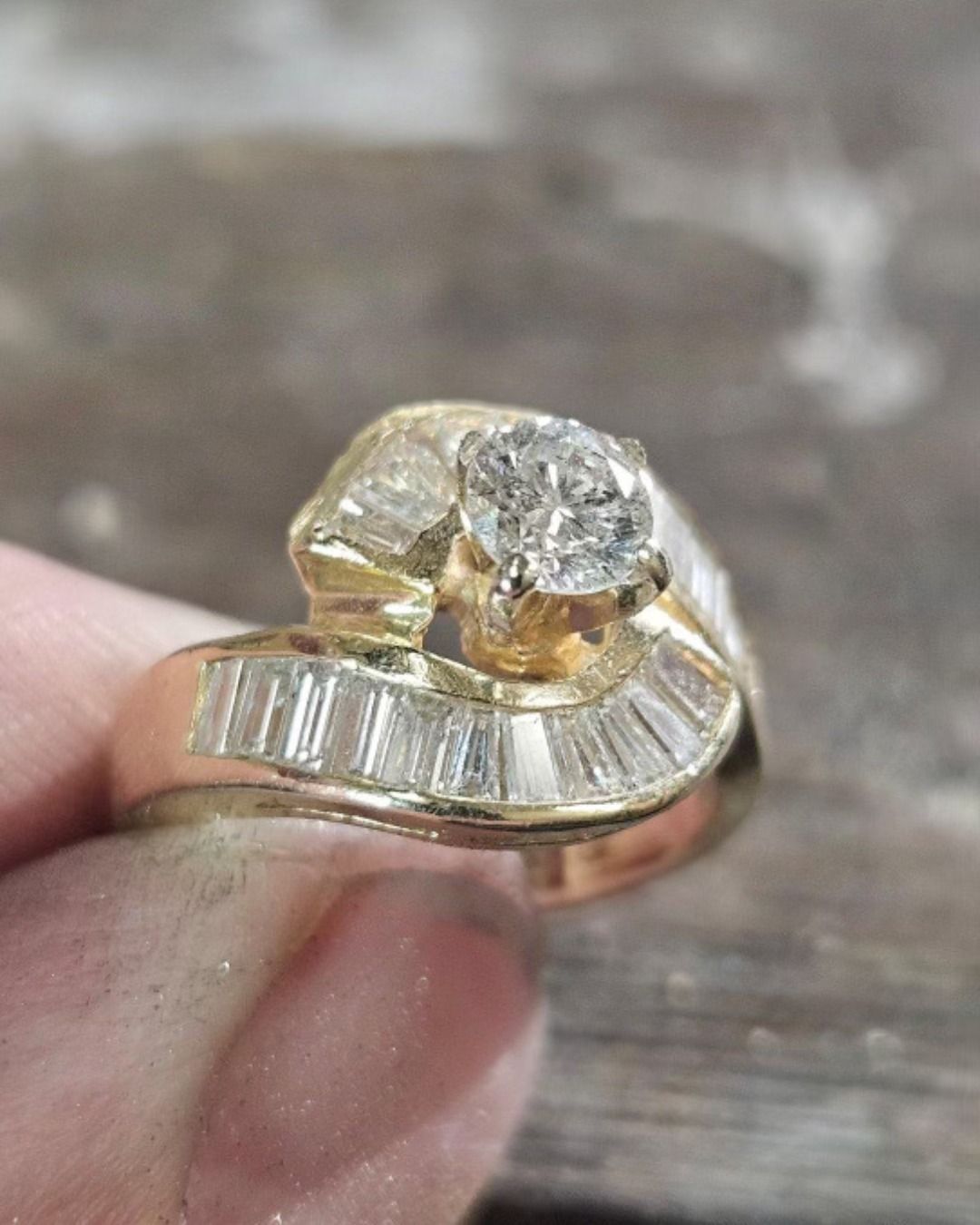 Gold ring with large central diamond and baguette-cut diamonds on the band.