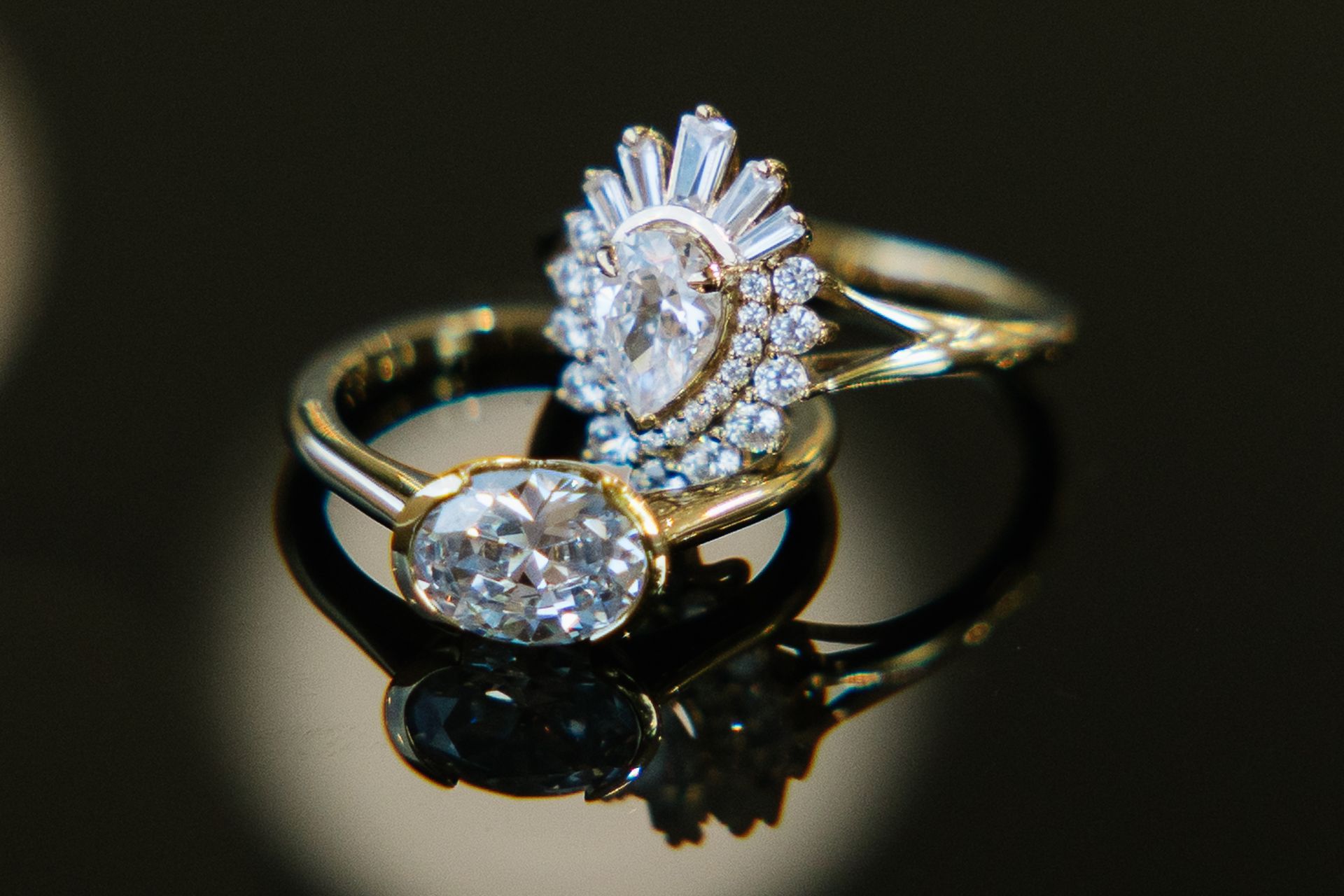 Two rings are sitting on top of each other on a black surface.