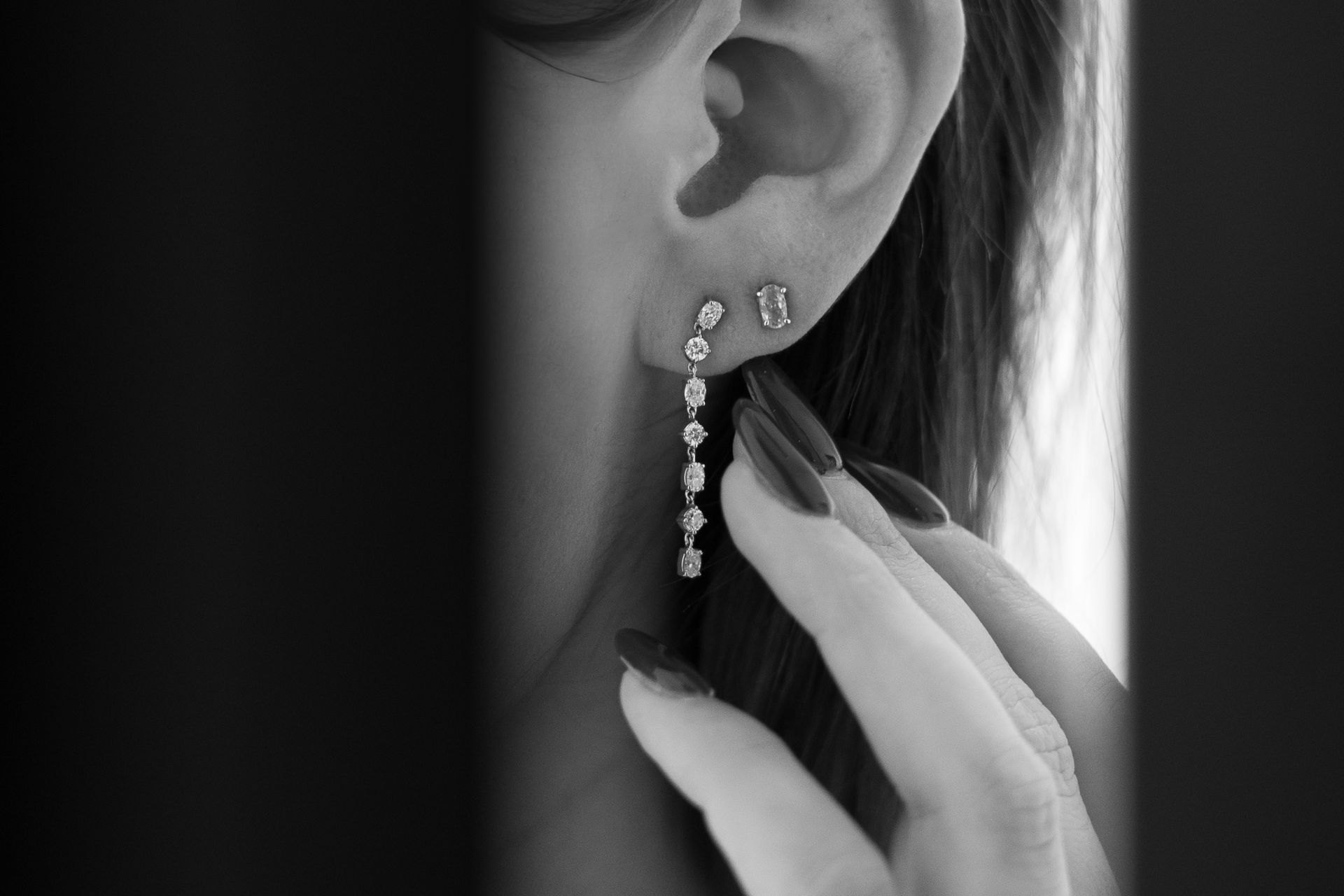 A black and white photo of a woman wearing earrings.