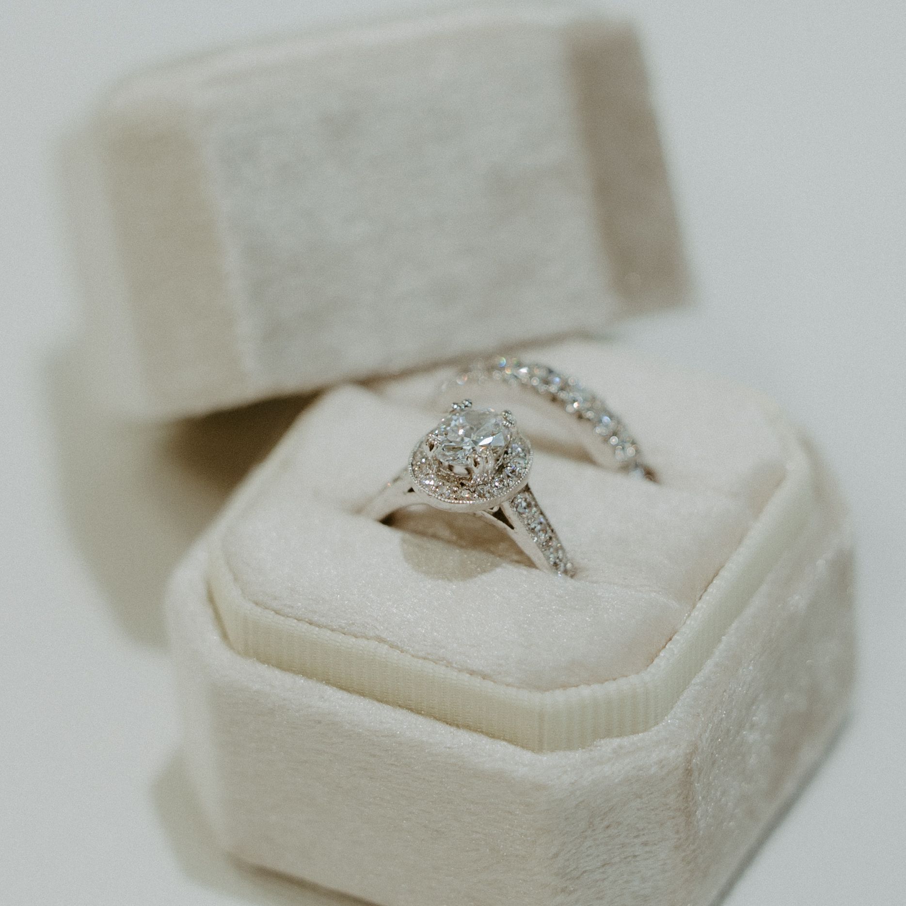 A wedding ring and engagement ring in a white box