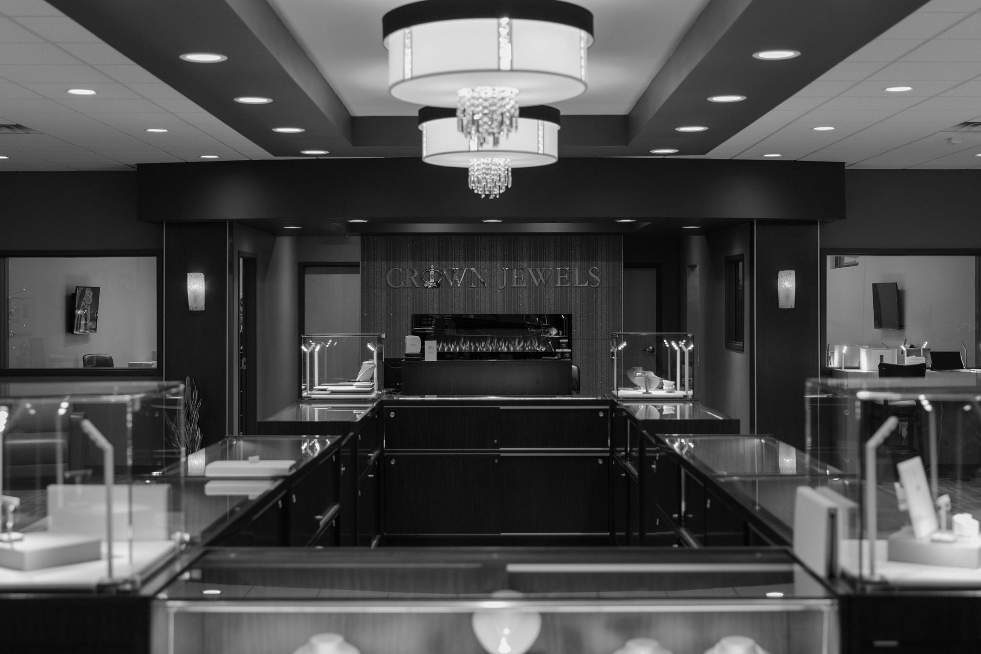 A black and white photo of a jewelry store with a chandelier hanging from the ceiling.