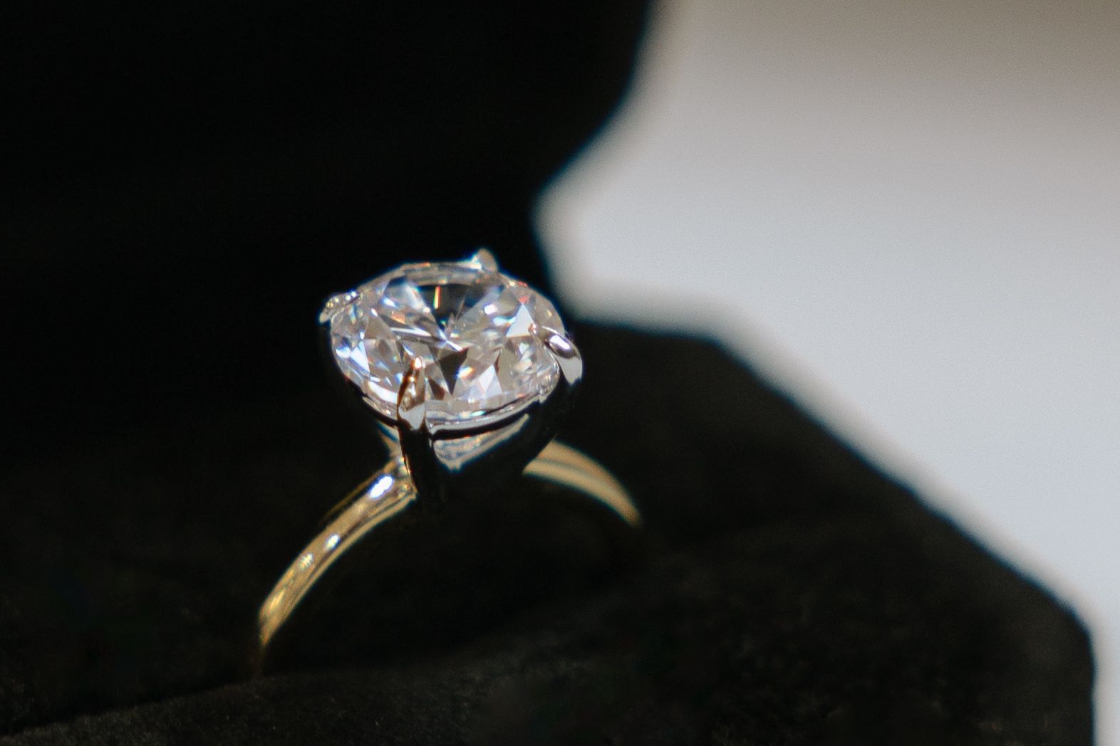 A close up of a diamond ring in a black box