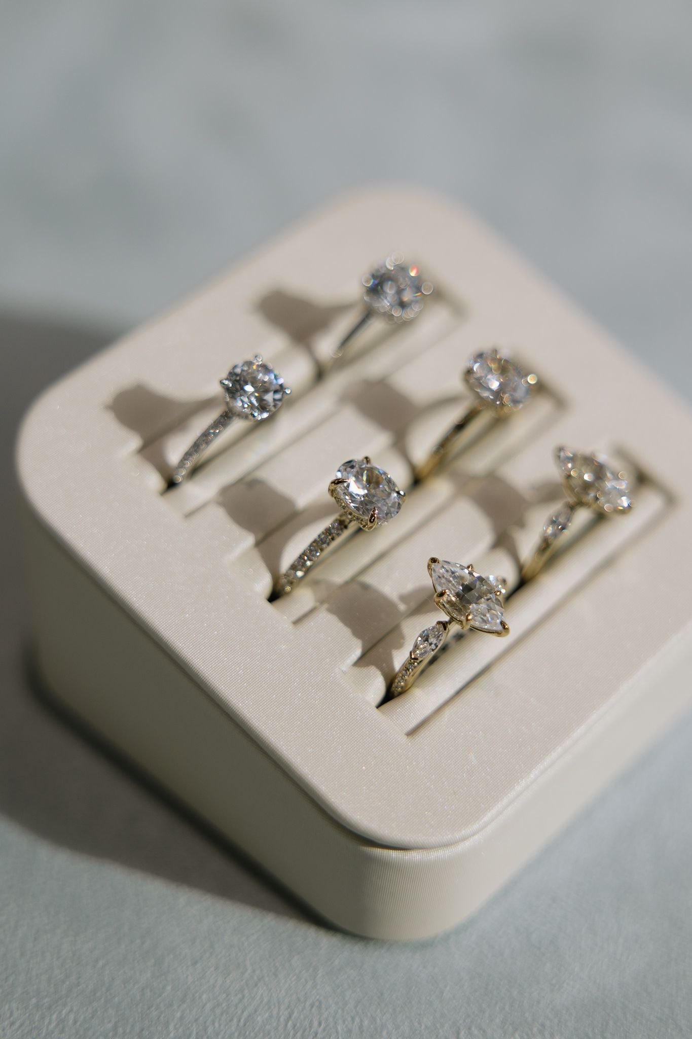 A white ring holder filled with rings on a table.