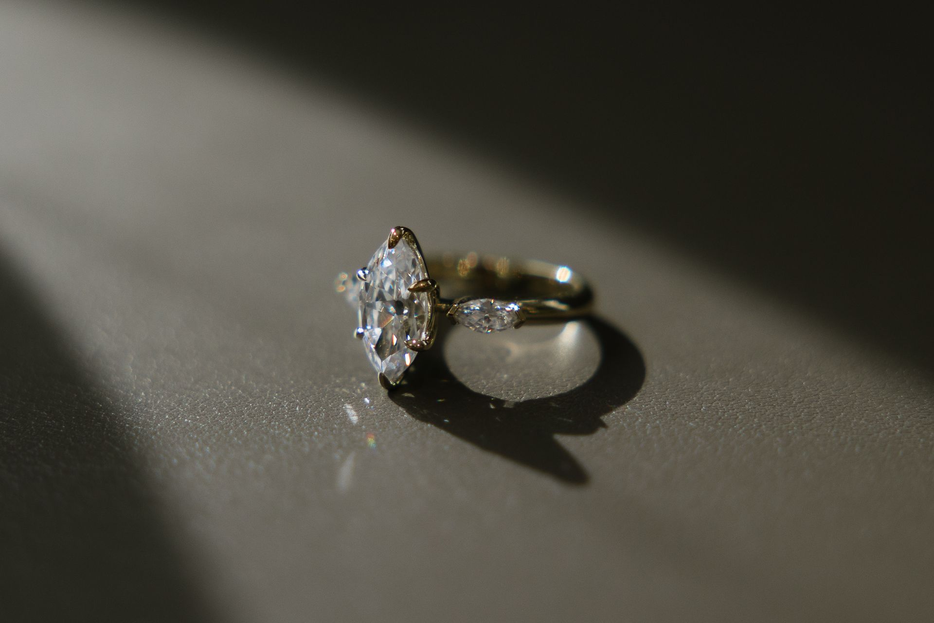A close up of a diamond ring on a table.
